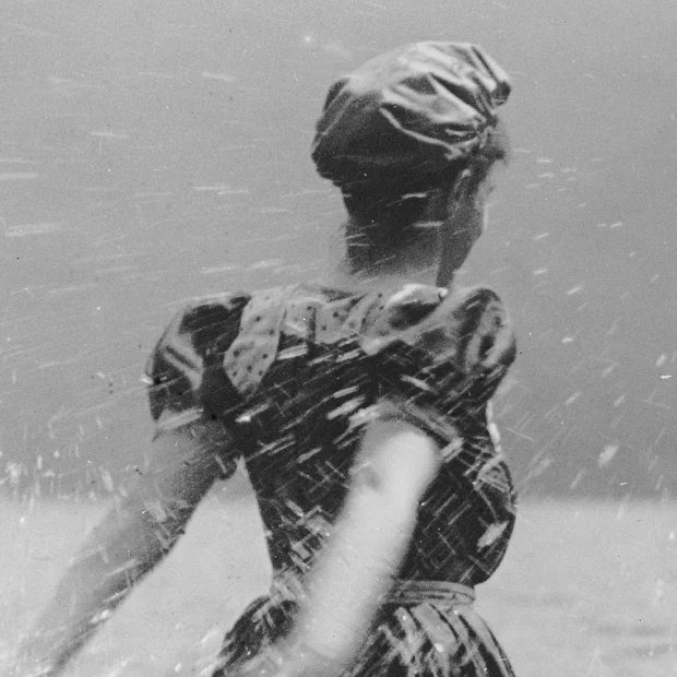 Femme sur la plage, éclaboussant l'eau.